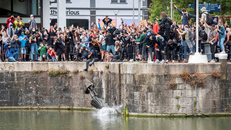 A statue of 17th century slave trader Edward Colston is pushed into water by protesters in Bristol, Britain, June 7, 2020 © Reuters / Keir Gravil