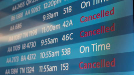 A flight-status screen at Los Angeles International Airport shows some of the cancelations by American Airlines on Sunday.