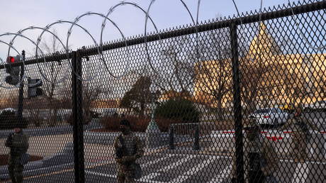 FILE PHOTO: National Guard troops are shown stationed behind a non-scalable fence in Washington days after the January 6 Capitol riot.