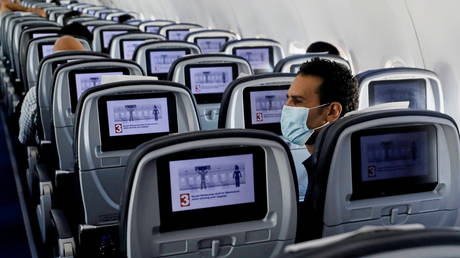 FILE PHOTO: A traveller wears a protective face mask on a plane at Cairo International Airport in Cairo, Egypt, August 25, © Reuters / Mohamed Abd El Ghany