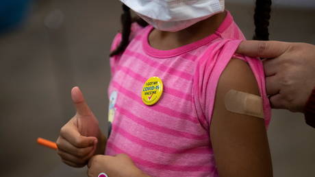 One five-year-old gives a thumbs-up after receiving her first dose of the Covid vaccine inside Mary's Center in Washington, US, on November 3, 2021. © Reuters/Tom Brenner
