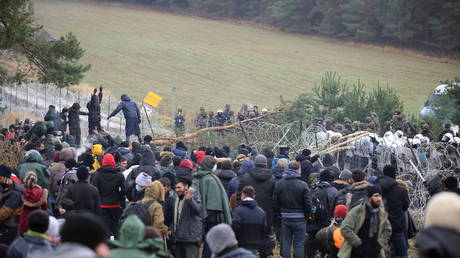 Migrants gather near a barbed wire fence in an attempt to cross the border with Poland in the Grodno region, Belarus November 8, 2021. Leonid Scheglov/BelTA/Handout via REUTERS