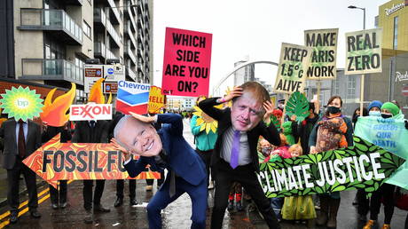 Climate activists hold signs and masks as they demonstrate outside the UN Climate Change Conference (COP26) venue, in Glasgow, Scotland, Britain November 12, 2021 © REUTERS/Dylan Martinez