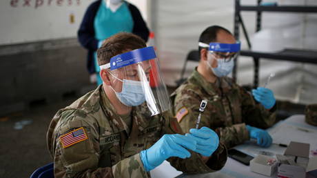 A US Army soldier prepares Covid-19 vaccines to inoculate people in Miami, Florida