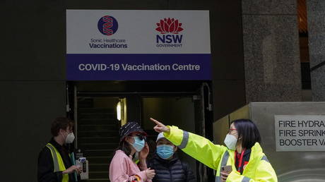 A staff member speaks at the entrance to a vaccination centre as lockdown remains in place to curb COVID-19 in Sydney, Australia, August 18, 2021