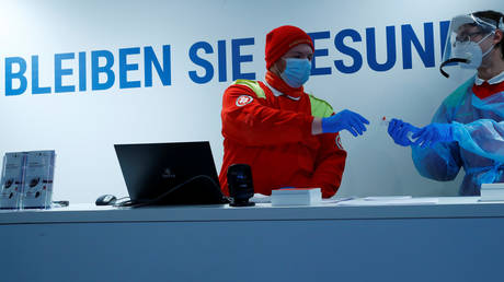 FILE PHOTO: Health care workers exchange a fast PCR test sample in a mobile laboratory truck, amid the coronavirus disease (COVID-19) outbreak, in Soelden, Austria, October 15, 2020. REUTERS/Leonhard Foeger