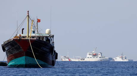 FILE PHOTO: Chinese Coast Guard vessels patrol near a fishing boat in a disputed area of the South China Sea.