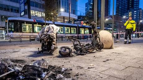 A burned electric scooter is seen after an anti-lockdown protest in Rotterdam, Netherlands, November 19, 2021 © AFP / Jeffrey Groeneweg