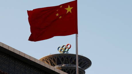 FILE PHOTO: A Chinese flag flutters near the Olympic rings on the Olympic Tower in Beijing, China, on November 11, 2021.