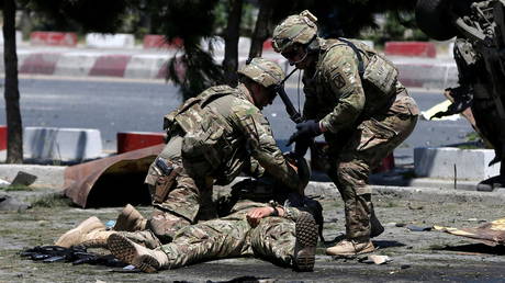 US troops are shown tending to a wounded soldier after a June 2015 blast in Kabul. America's longest war ended in August with a chaotic withdrawal from Afghanistan.
