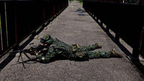 FILE PHOTO: A soldier lies with a rifle by a beach during an annual anti-invasion drill in Tainan, Taiwan, September 14, 2021.