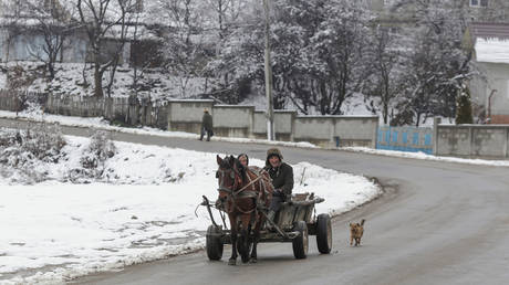 عکس عکس.  یک کالسکه اسب کشیده در خیابانی در دراگومیرستی، شهرستان دامبوویتا، رومانی به تصویر کشیده شده است.