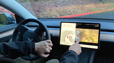 Tesla owner, demonstrates on a closed course in Portland, Oregon, how he can play video games on the vehicle's console while driving