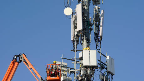 FILE PHOTO: Workers install 5G telecommunications equipment on a cell tower in Orem, Utah