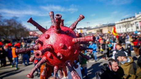FILE PHOTO: A protester holds a model of the coronavirus in Kassel, Germany, March 2021. © Reuters/Thilo Schmeulgen