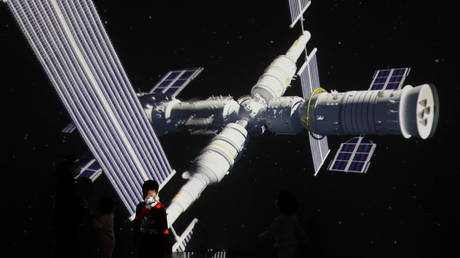 FILE PHOTO: A child stands near a giant screen showing the image of the Tianhe space station at the China Science and Technology Museum in Beijing, China, April 24, 2021 © Reuters / Tingshu Wang