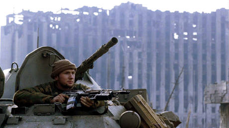 FILE PHOTO. A member of the Russian special forces looks from an APC in front of the demolished presidential palace in rebel Chechen capital of Grozny on January 28, 1995. © Reuters / STR New