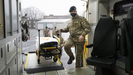 Members of the military practice loading and unloading a stretcher into an ambulance at Maindy Barracks. © Matthew Horwood / Getty Images)