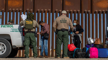 US Border Patrol agents are shown with migrants who turned themselves in last May in Yuma, Arizona.