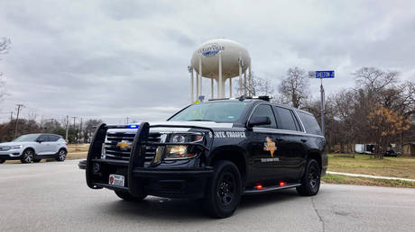 A Texas state trooper blocks traffic on a road leading to a Colleyville, Texas, synagogue where a man apparently took hostages, Saturday, Jan. 15, 2022.  © AP Photo/Jake Bleiberg)