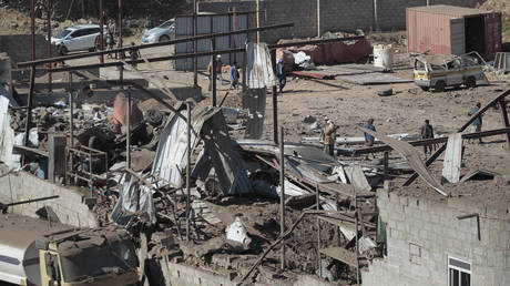 FILE PHOTO: People inspect the site of airstrikes by a Saudi-led coalition on a workshop, in Sanaa, Yemen, Dec. 5, 2021