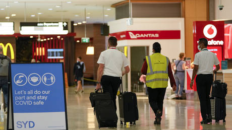 A flight crew walk through the terminal at Sydney Airport, Monday, Nov. 29, 2021