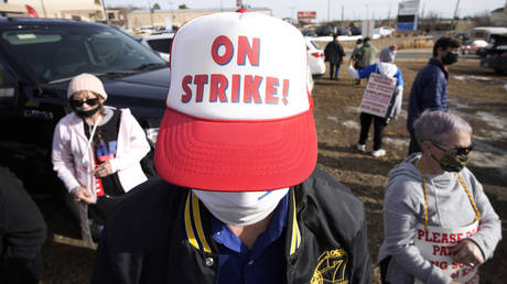 Kevin Schneider wears a cap with a message as grocery store workers picket outside a King Soopers store after rejecting the latest contract offer from the chain that is owned by Kroger, Co., Thursday, Jan. 13, 2022. © AP Photo / David Zalubowski