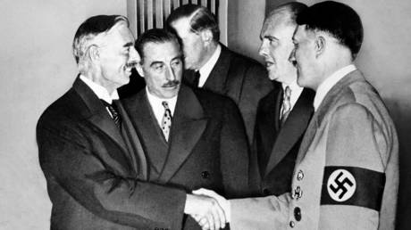 FILE PHOTO. Adolf Hitler greets Neville chamberlain at Munich 1938. © Getty Images / Universal History Archive