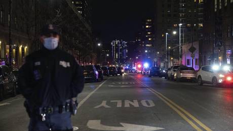 An NYPD officer stands at the scene of shooting in Harlem on Friday, Jan. 21, 2022, in New York