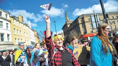 A participant is seen holding a flag during the Trans Pride march in Dundee. © Stewart Kirby / SOPA Images / LightRocket via Getty Images