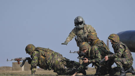 FILE PHOTO: An US airman directs Romanian servicemen during a joint US-Romanian air assault exercise , March 8, 2017. © AP Photo/Vadim Ghirda