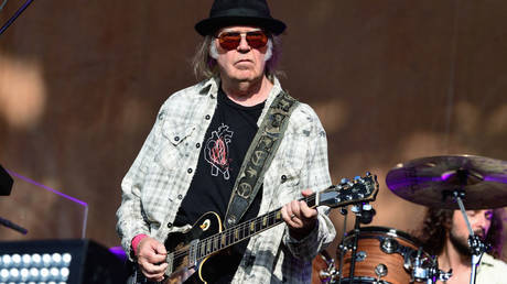 Neil Young is shown performing at a 2019 concert in London.