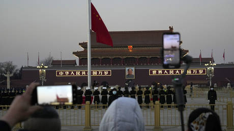 FILE PHOTO: Residents watch the lowering of the Chinese flag on Tiananmen Square in Beijing, China, January 18, 2022. © AP/Ng Han Guan