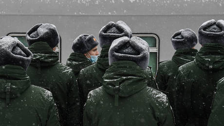 Conscripts for the Russian Army wearing protective face masks stand at attention before being sent to the place of their military service, in Novosibirsk, Russia. © Sputnik / Alexandr Kryazhev