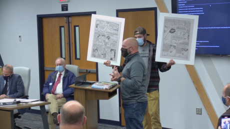 NKC School District Board of Education meeting where Ryan Utterback is seen holding up pictures to protest LGBTQ-themed books. © YouTube / NKCSchools