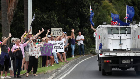 People greet an anti-mandate convoy heading through Warkworth in Auckland, New Zealand on February 06, 2022