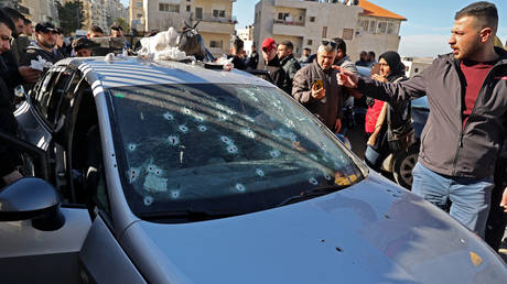 Palestinians inspect a bullet-riddled car belonging to three Palestinians killed by Israeli forces in the occupied West Bank city of Nablus, on February 8, 2022. © AFP / JAAFAR ASHTIYEH
