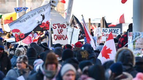 Protesters near Parliament Hill hold signs condemning the vaccine mandates imposed by Canadian Prime Minister Justin Trudeau on February 5, 2022 in Ottawa, Canada. © Minas Panagiotakis / Getty Images