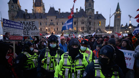 Police officers walk away from demonstrators during a protest outside the parliament of Canada in Ottawa. February 11, 2022. © AFP / Ed Jones
