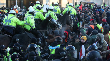 Mounted police officers charge a crowd of protesters in Ottawa, Canada, February 18, 2022 © Getty Images / Steve Russell