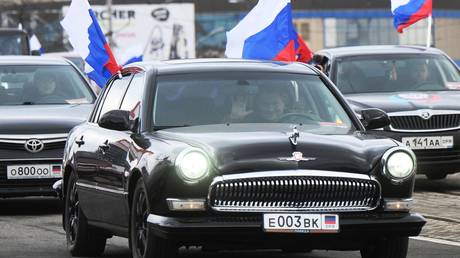 Residents wave Russian flags as they ride cars after the signing of documents on the recognition by the Russian Federation of the Luhansk People's Republic (LPR) and the Donetsk People's Republic (DPR) in Donetsk, Donetsk People's Republic. © Sputnik/Ilya Pitalev