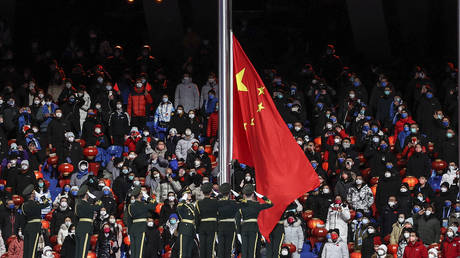 Chinese national flag flies during the closing ceremony of the Winter Olympics at Beijing National Stadium. © Maja Hitij / Getty Images