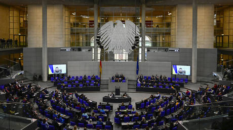 Members of parliament and of the German government listen as Ukrainian President Volodymyr Zelensky appears on two screens to address via videolink the German lower house of parliament Bundestag, on March 17, 2022 in Berlin. © AFP / Tobias SCHWARZ
