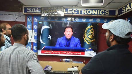 FILE PHOTO: People listen to Pakistan's Prime Minister Imran Khan addressing the nation on February 28, 2022