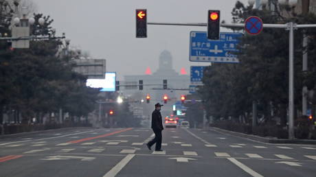 A man walks across an empty road in Changchun in northeast China's Jilin province Monday, March 14, 2022, the fourth day of the Covid-19 lockdown. © Feature China / Future Publishing via Getty Images