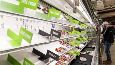 A shopper looks at nearly empty shelves of meat at a supermarket in Washington, DC, January 4, 2022 © AP / Andrew Harnik