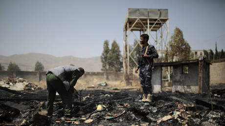 Yemeni police inspect a site of Saudi airstrikes targeting two houses in Sanaa, Yemen, March 26, 2022.