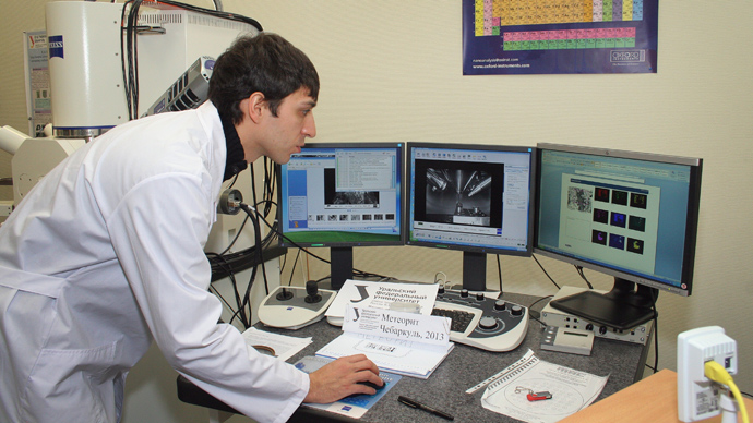 Scientist working with pieces of porous black rock, reportedly fragments of the meteor that spectacularly plunged over Russia's Ural Mountains, at the universityâs lab in Yekaterinburg (AFP Photo / Ural Federal University / Alexander Khlopotov)