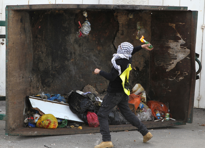 A masked Palestinian youth throws a fire bomb towards Israeli forces during clashes outside Israel's Ofer prison near Ramallah on February 25, 2013. (AFP Photo / Abbas Momani)
