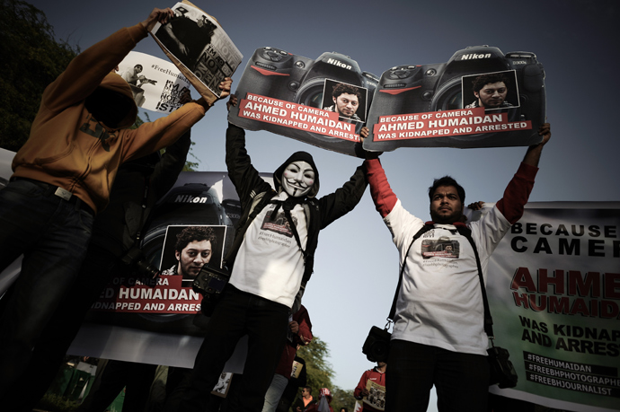 Bahraini photographers hold placards in solidarity with arrested photographer Ahmed Humaidan during a new protest of Shiite Muslims against an appeals court upholding jail terms for 13 activists on charges of plotting to overthrow Bahrain's monarchy, on January 12, 2013 in the village of Barbar, west of Manama (AFP Photo / Mohammed Al-Shaikh)